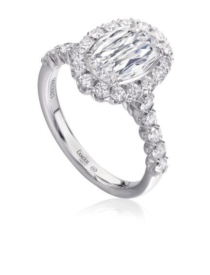 Classic design oval diamond engagement ring in 18K white gold with halo and diamond sides.